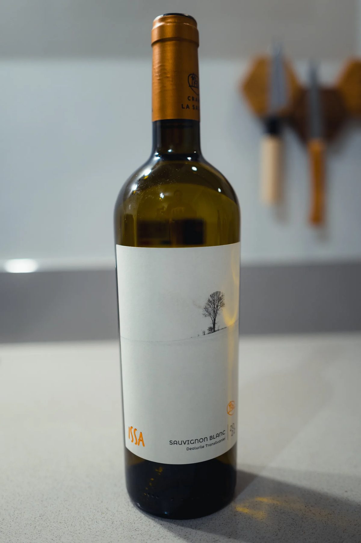 ISSA Sauvignon Blanc bottle on a kitchen counter with a wintry tree label