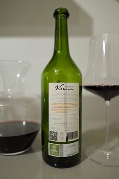 Achterzijde van een fles Vivanco Rioja met karaf en glas op een lichte ondergrond