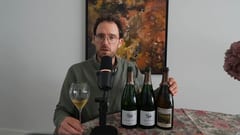 Jeroen Vonk aan tafel met een glas champagne in de hand en drie flessen B. Girardin naast elkaar, tijdens de blindproef over gistrijping