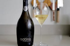 Fles Henri Chauvet Adonis 2020 Blanc de Blancs staand naast een vol glas op een keukenblad