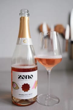 Fles Zeno Sparkling Rosé alcoholvrije mousserende rosé naast een glas