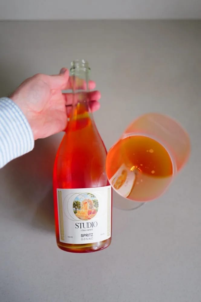 Kolonne Null Spritz Studio Italiano wordt ingeschonken, met een schijf sinaasappel in het glas