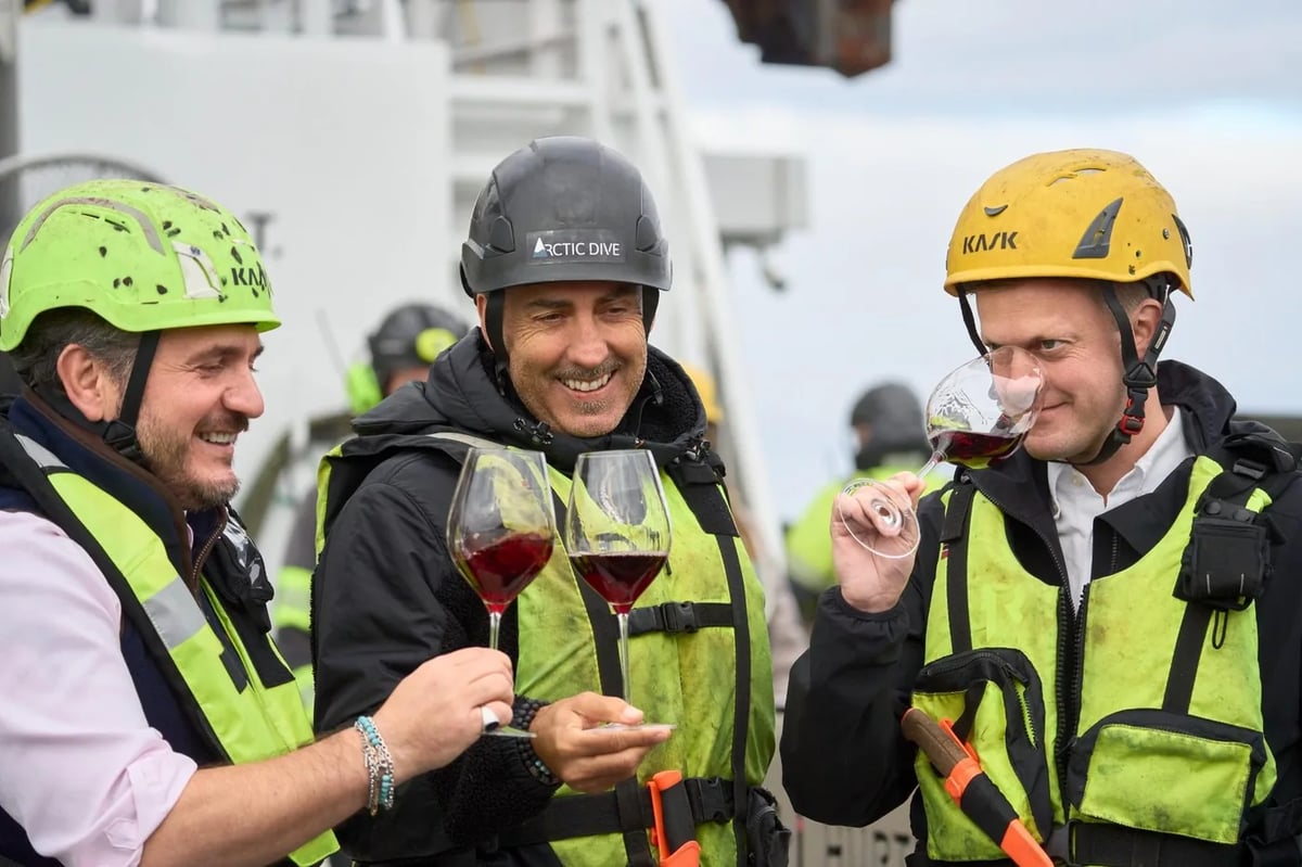 Tani Gurra, Enrico Rivetto en Henrik Dahl Jahnsen proeven met helm en reddingsvest de eerste flessen Arctic Barolo aan dek