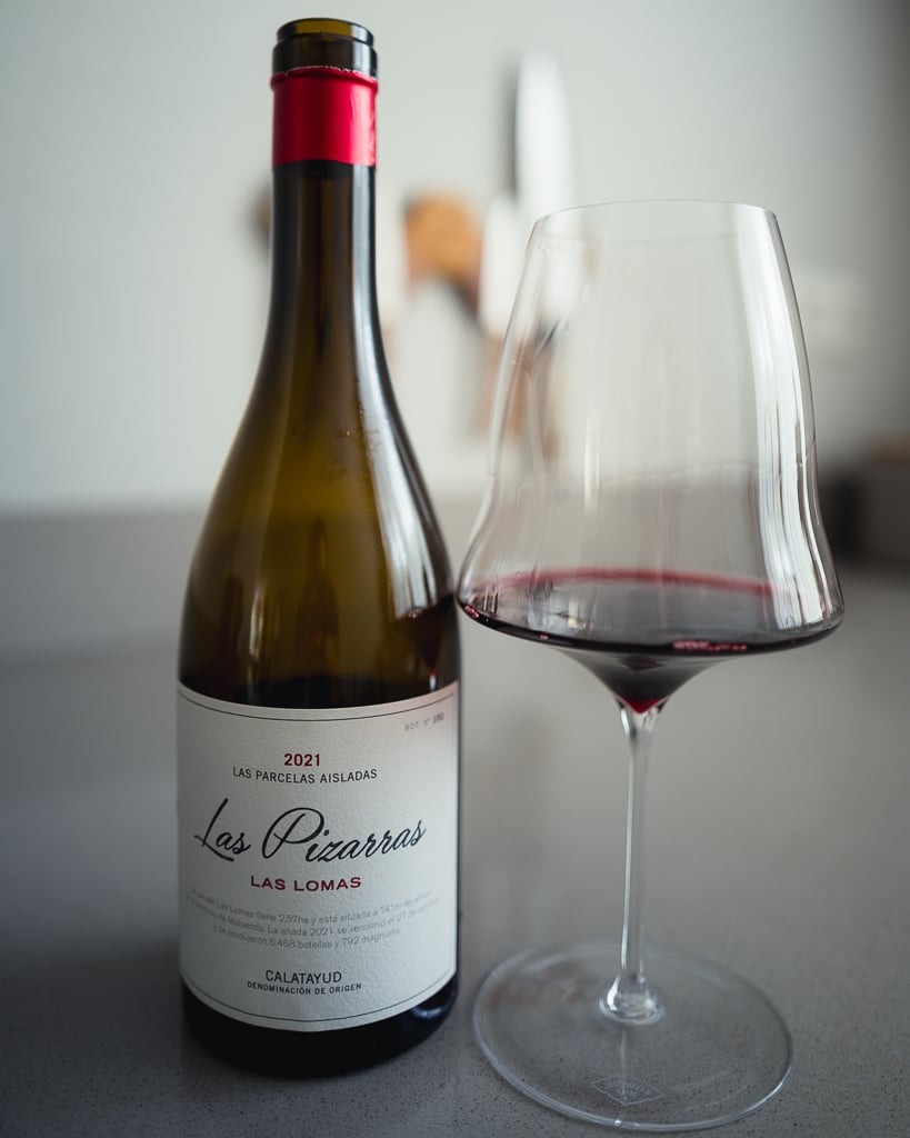 Fles Las Pizarras Las Lomas Garnacha 2021 uit Calatayud naast een glas rode wijn