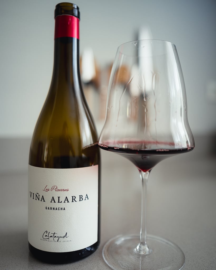 Fles Las Pizarras Viña Alarba Garnacha naast een glas rode wijn op het aanrecht