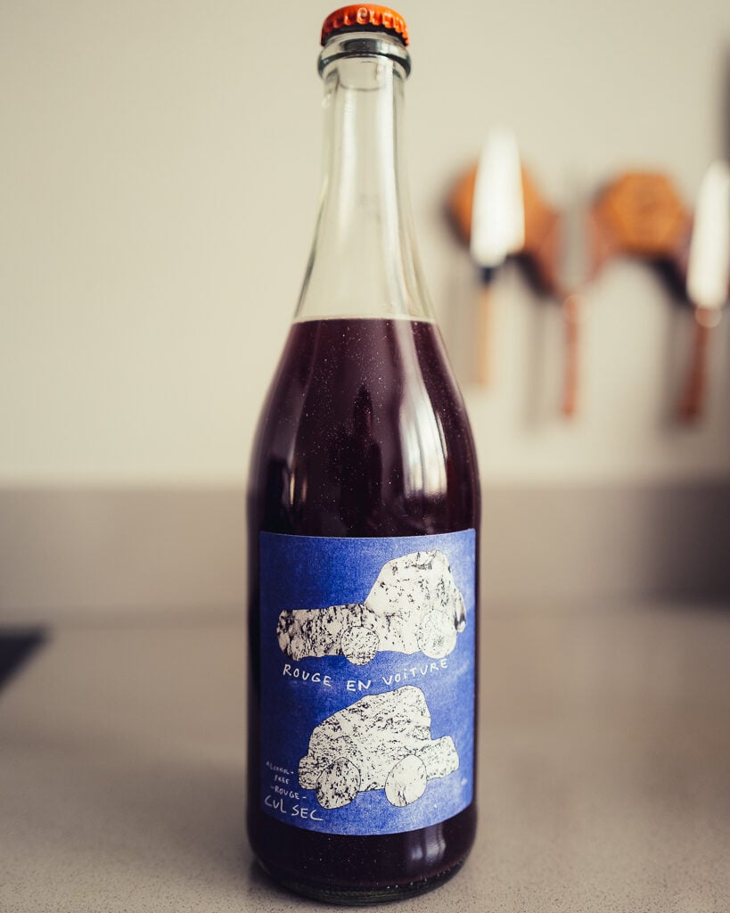 Cul Sec Rouge en Voiture alcohol-free red bottle with blue car label on a counter
