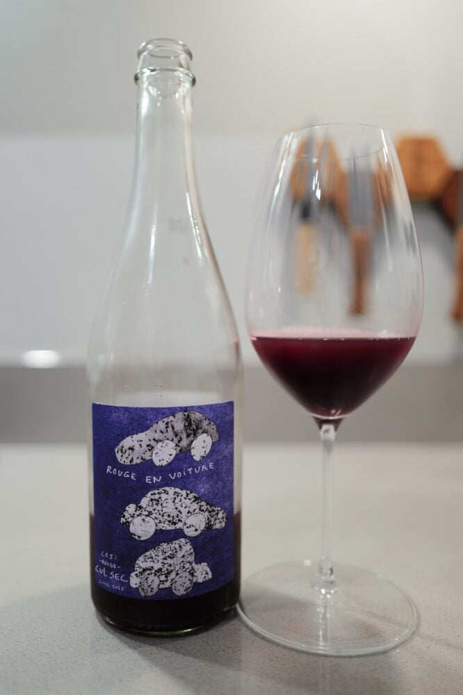Fles Cul Sec Rouge en Voiture met paars auto-etiket naast een glas donkerrode wijnproxy