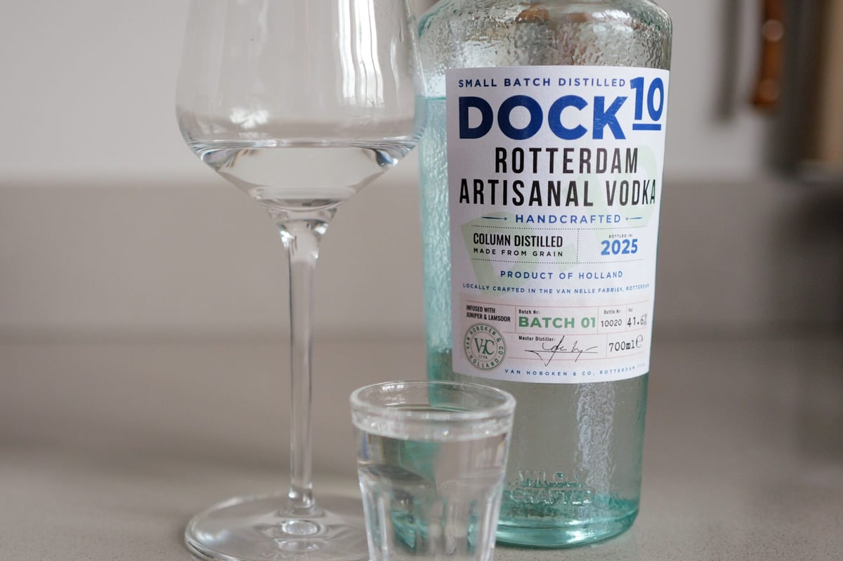 Close-up fles DOCK10 vodka, batch 01, met wijnglas en borrelglaasje water