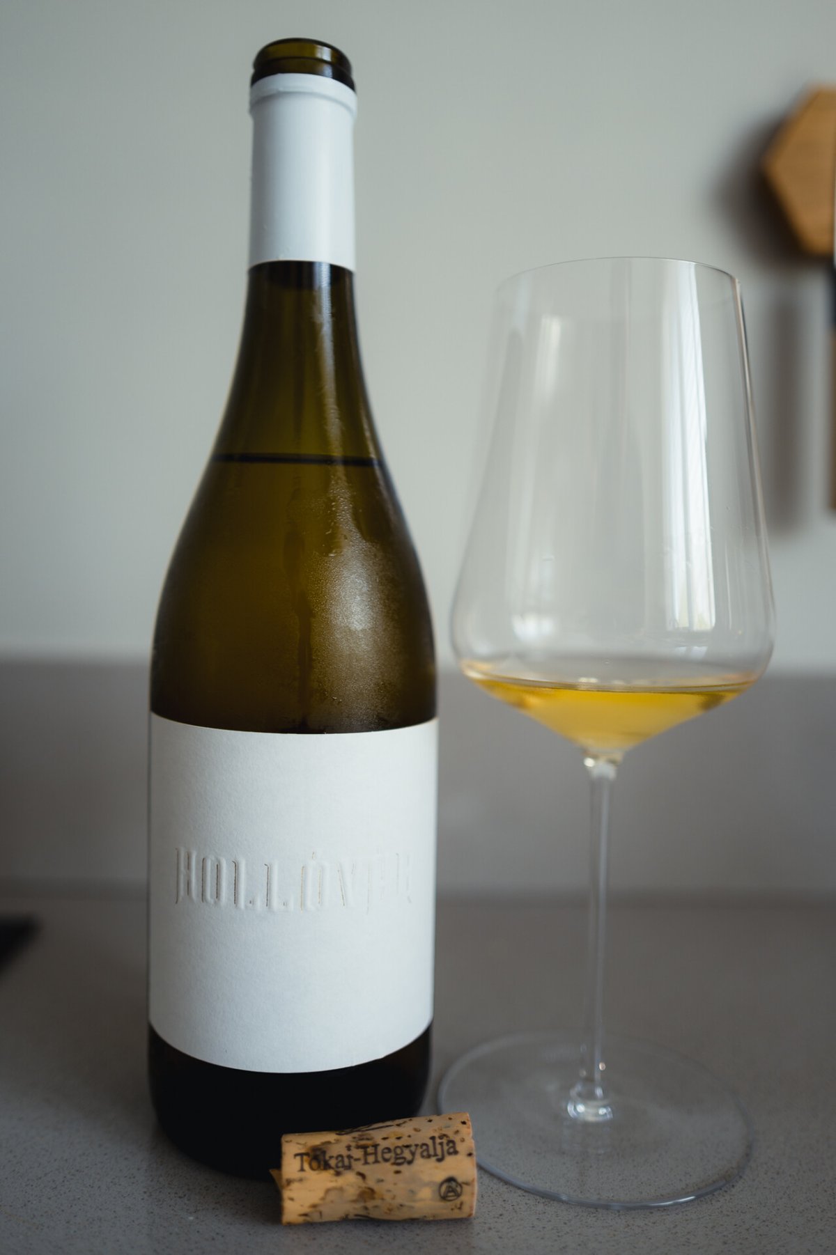 Fles Hollóvár Tokaji met glas goudgele wijn en kurk met opschrift Tokaj-Hegyalja