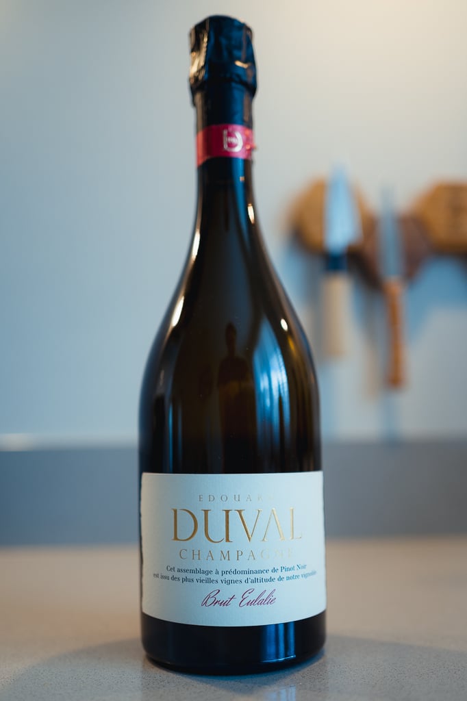 Fles Edouard Duval Brut Eulalie met rood kapsel rechtop op een aanrecht