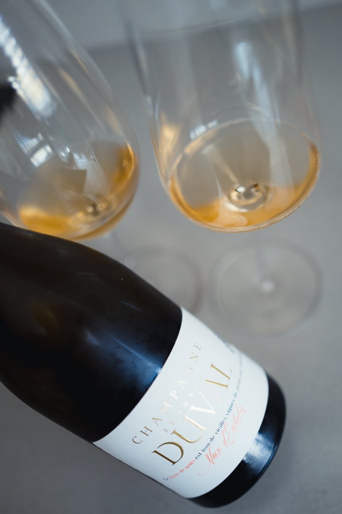 Twee glazen goudgele champagne van bovenaf met liggende fles Edouard Duval Noir d'Eulalie