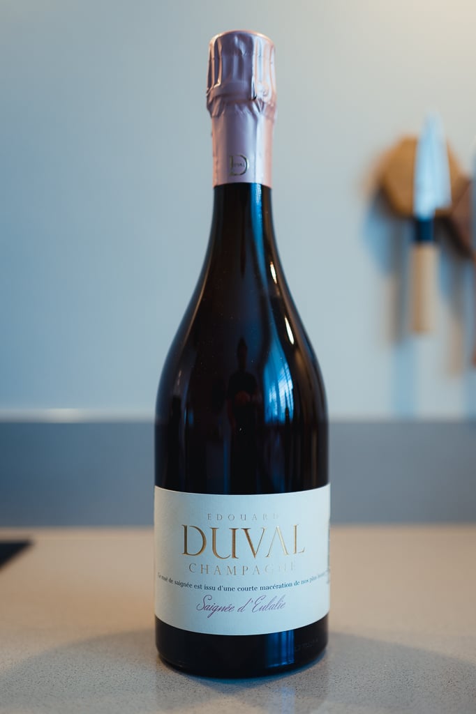 Fles Edouard Duval Saignée d'Eulalie met roze foliekapsel rechtop op een aanrecht