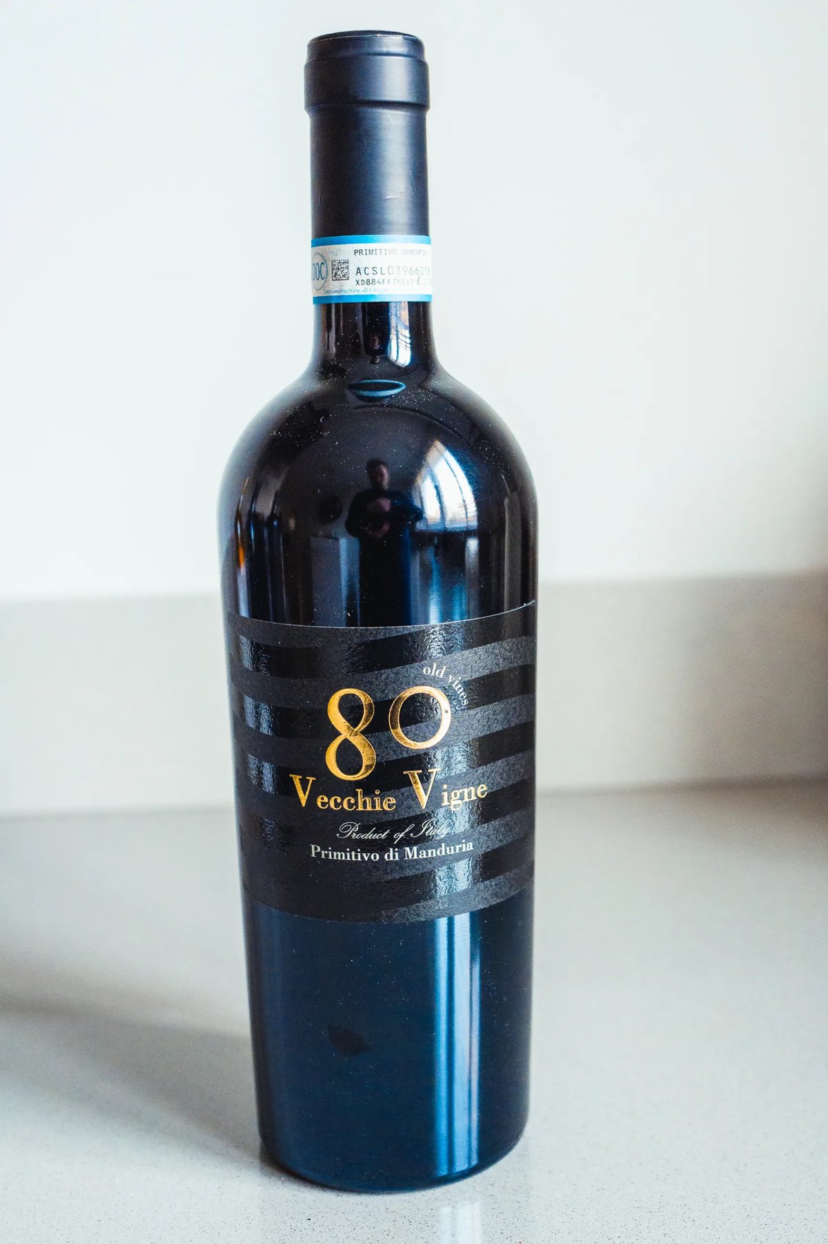 Donkere fles 80 Vecchie Vigne Primitivo di Manduria rechtop op een aanrecht