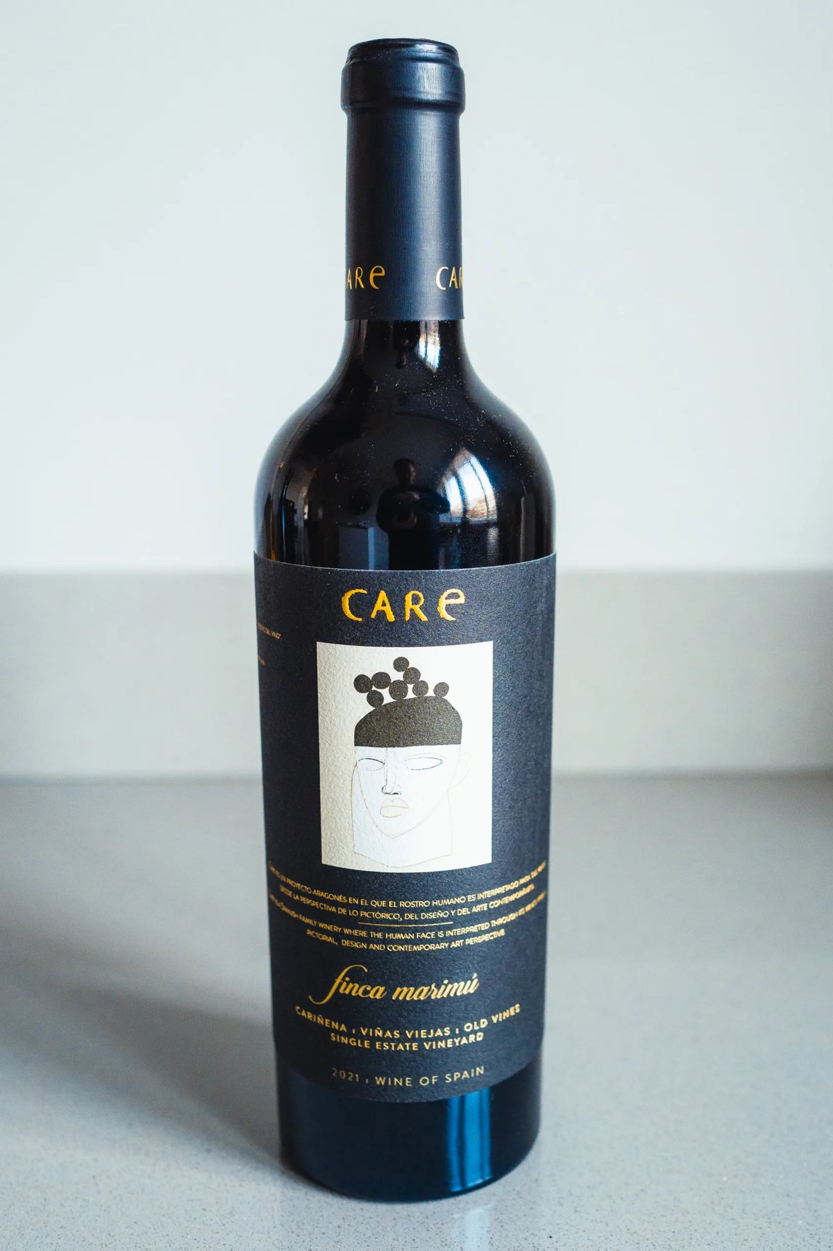 Donkere rode fles Care Finca Marina met gestileerd gezicht op het etiket