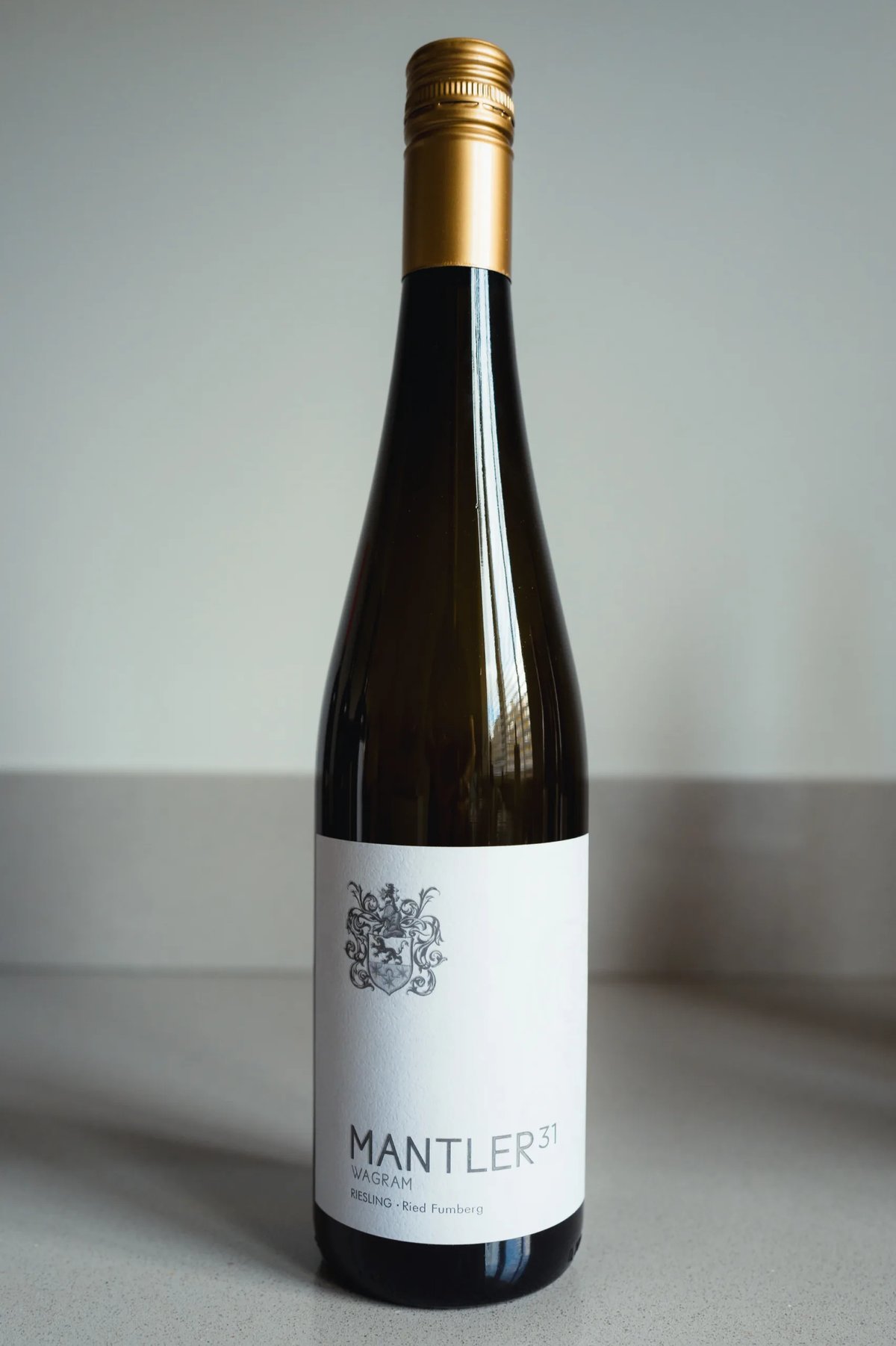 Fles Mantler 31 Riesling uit Wagram met goudkapsel rechtop op een aanrecht