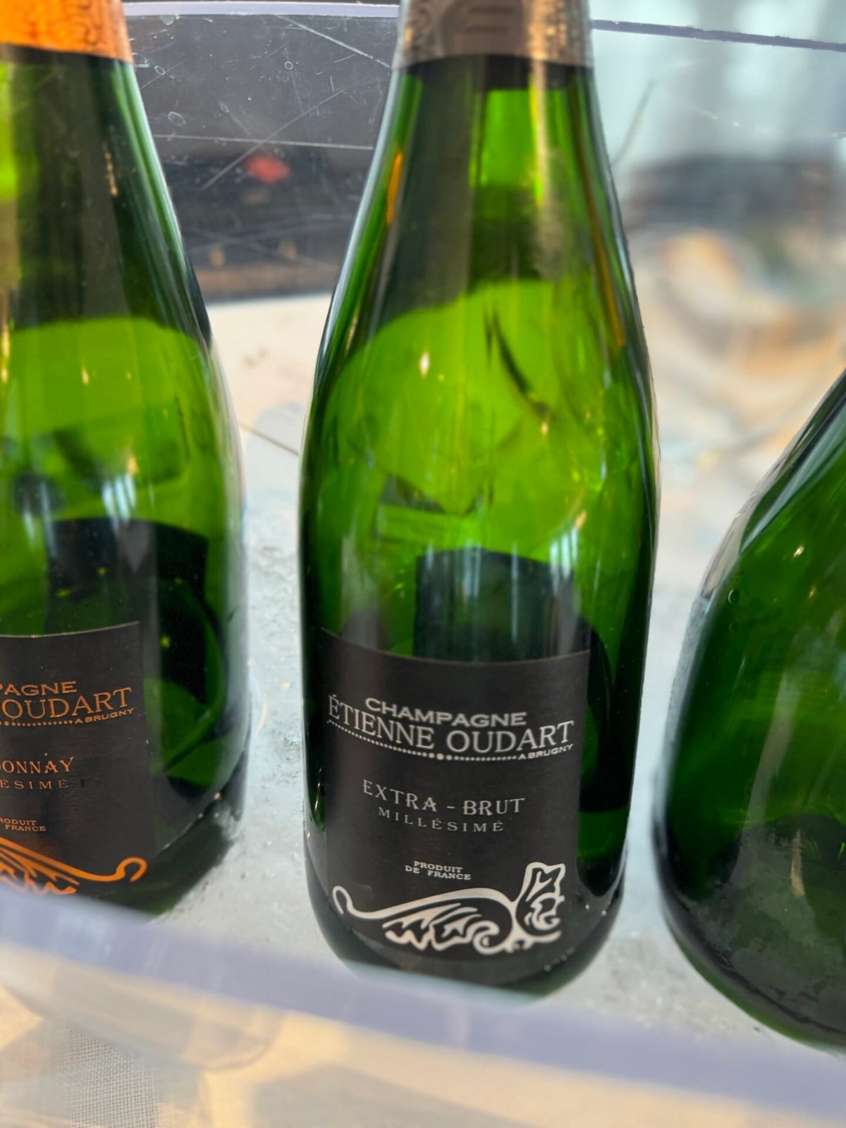 Twee groene flessen Champagne Étienne Oudart Extra-Brut Millésimé in een koelbak