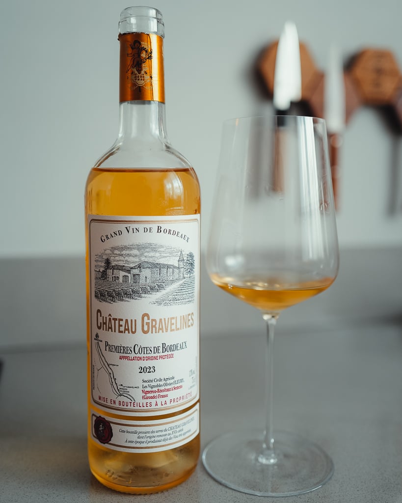 Fles Graves 2022 Château Fleury naast een glas rode wijn op een aanrecht