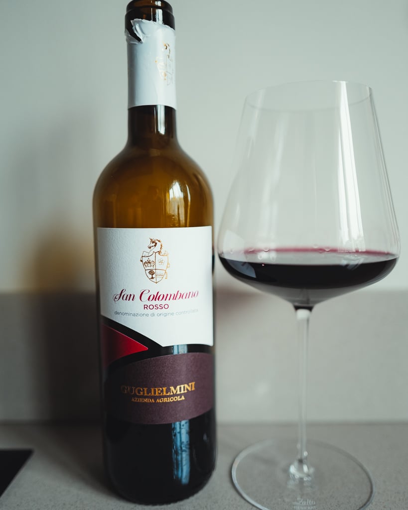 Fles San Colombano Rosso van Guglielmini naast een glas rode wijn