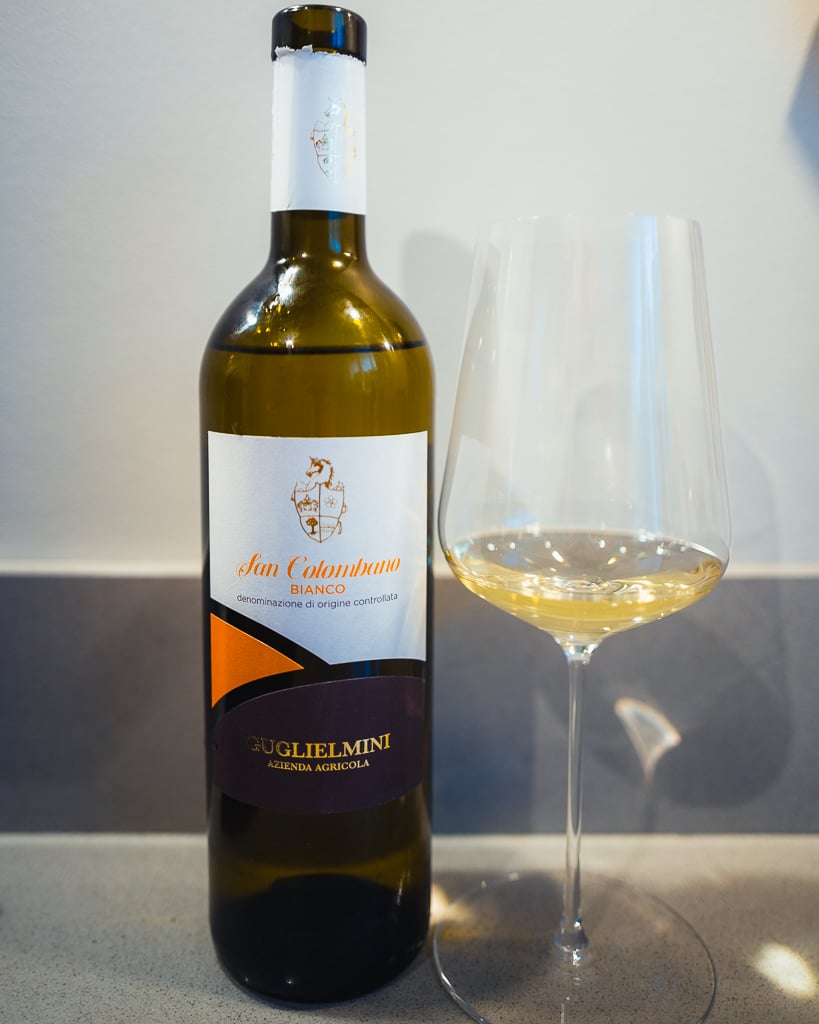 Fles San Colombano Bianco van Guglielmini naast een glas witte wijn