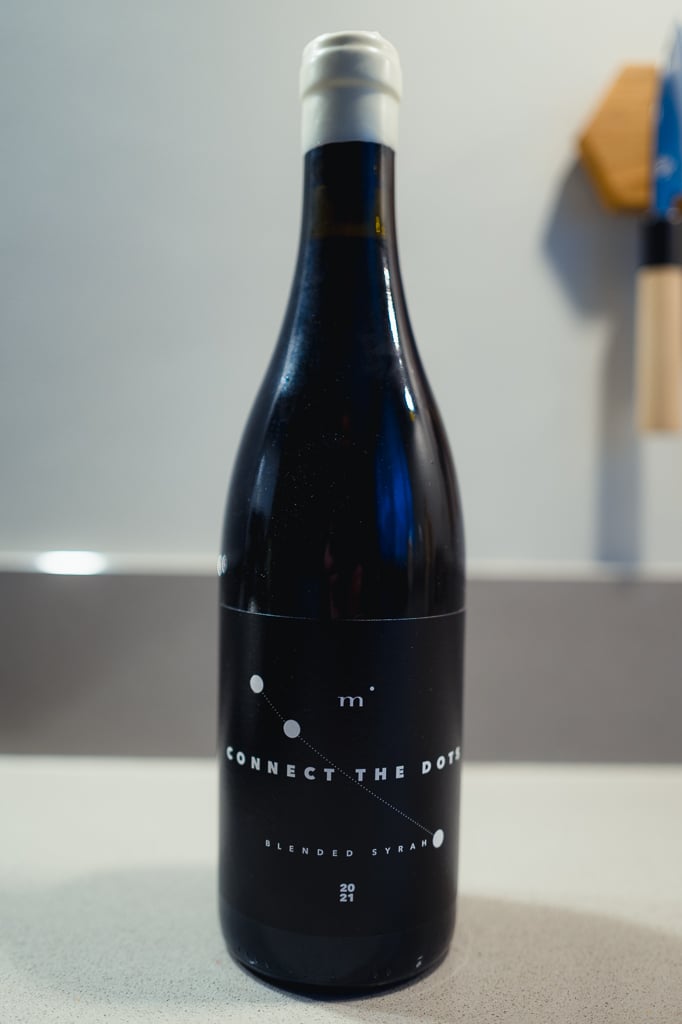 Fles Minimalist Connect the Dots Blended Syrah met witte capsule alleen op een aanrecht