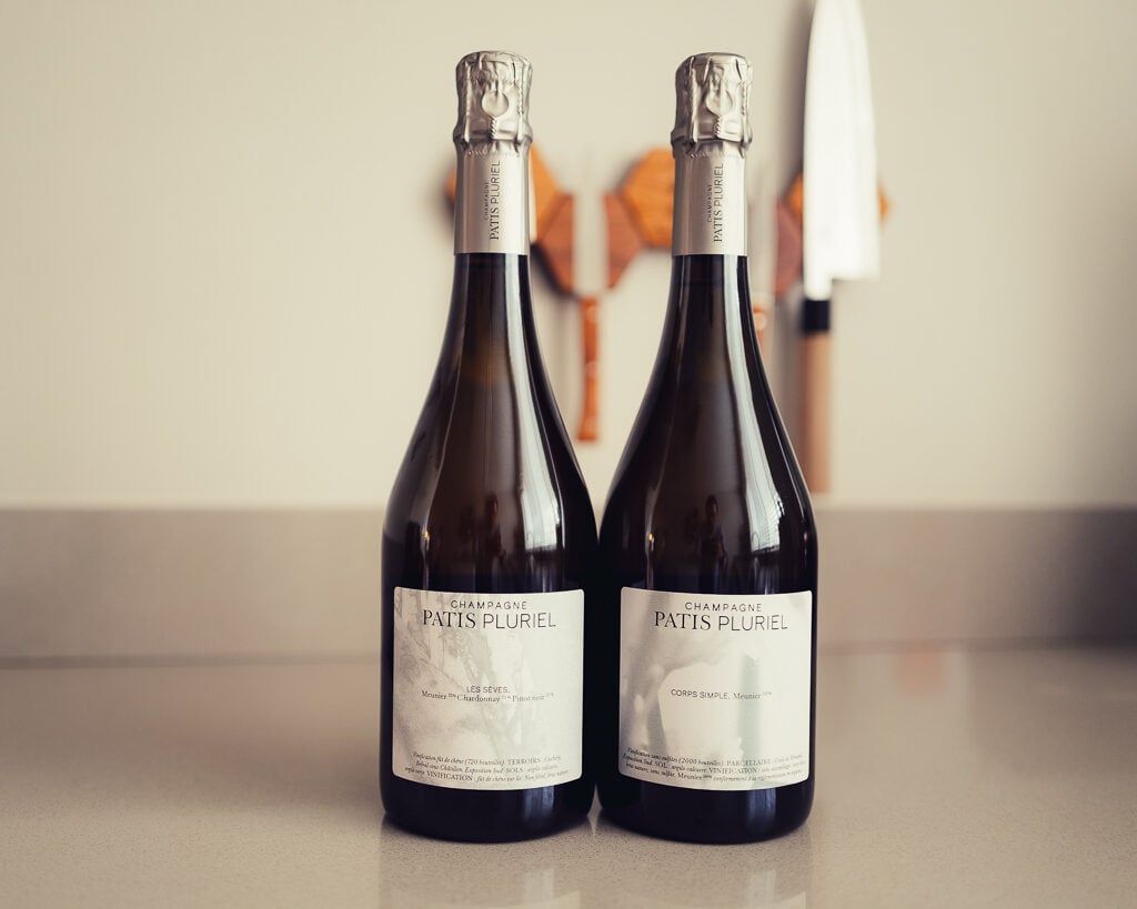 Twee flessen Champagne Patis Pluriel Les Sèves en Corps Simple naast elkaar