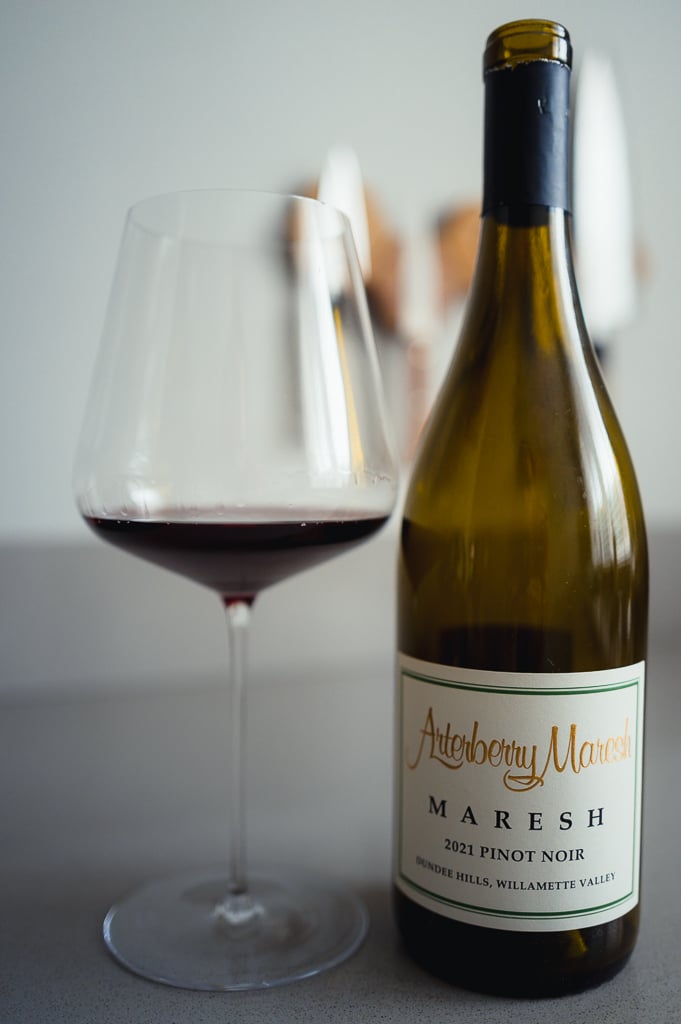 Fles Arterberry Maresh 2021 Pinot Noir naast glas rode wijn op aanrecht