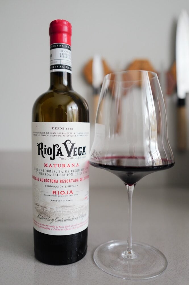 Fles Rioja Vega Maturana naast glas donkerrode wijn op aanrecht