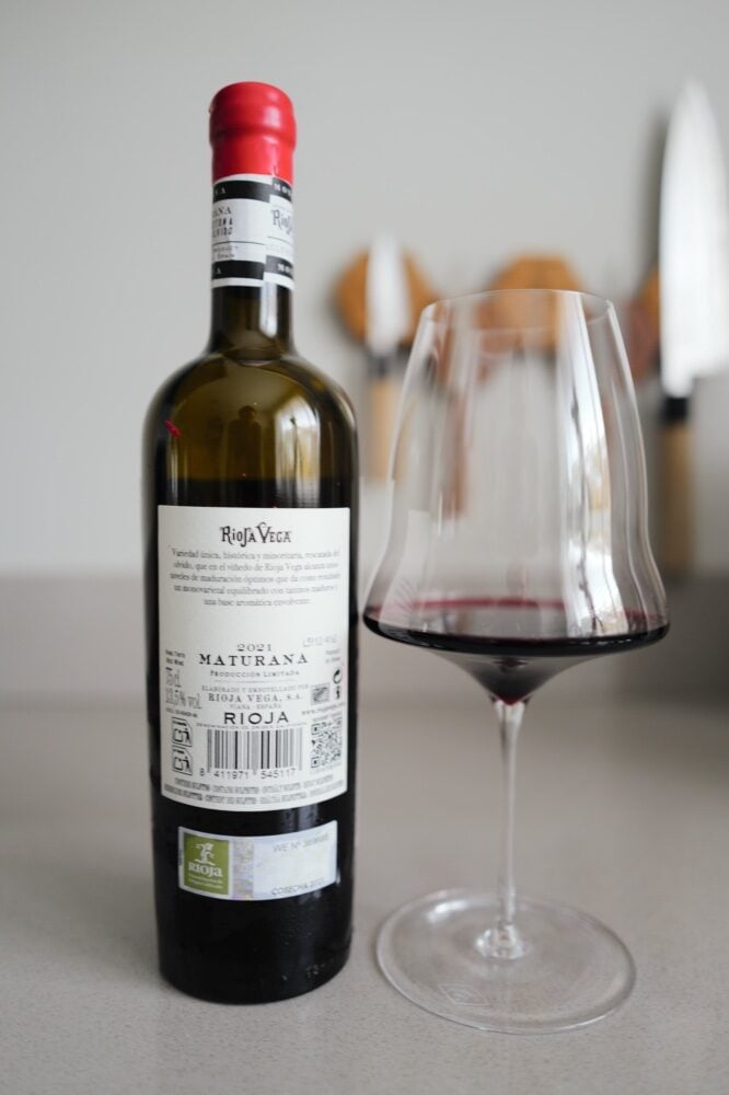 Rugetiket van fles Rioja Vega Maturana 2021 naast glas rode wijn