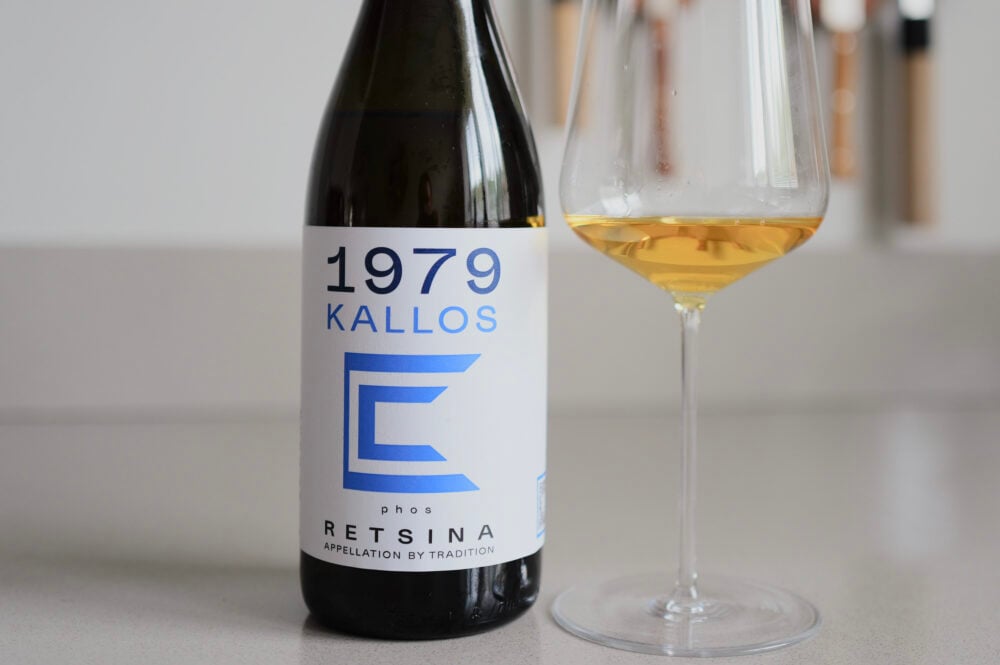 Fles 1979 Kallos Phos Retsina naast glas amberkleurige witte wijn