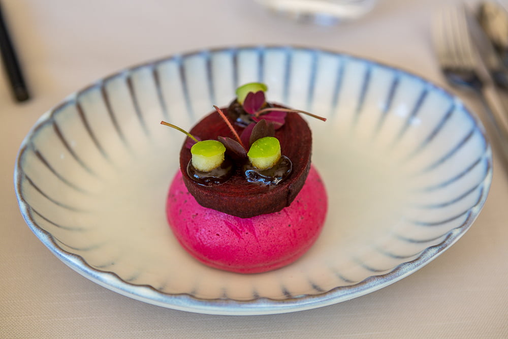 Gerecht met rode bietenmousse en chocoladetaartje op gestreept bord