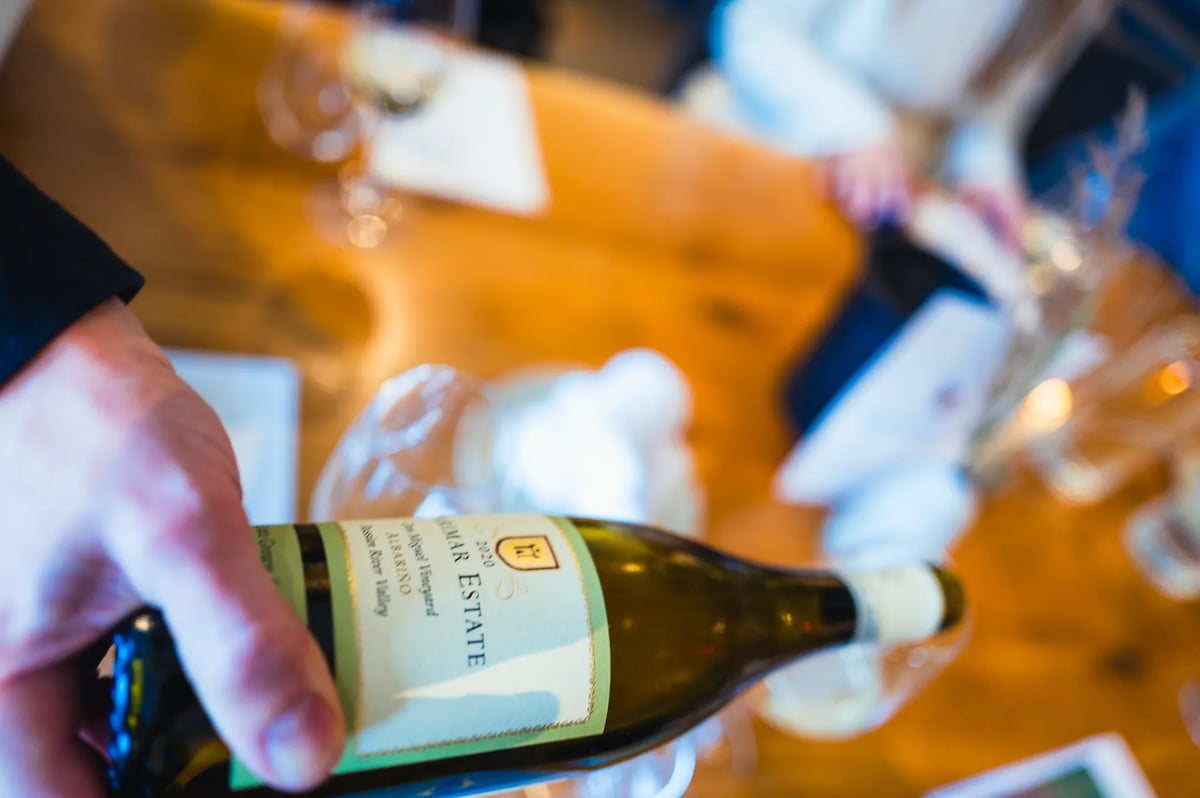 Hand toont een fles Marimar Estate Albariño tijdens de proeverij