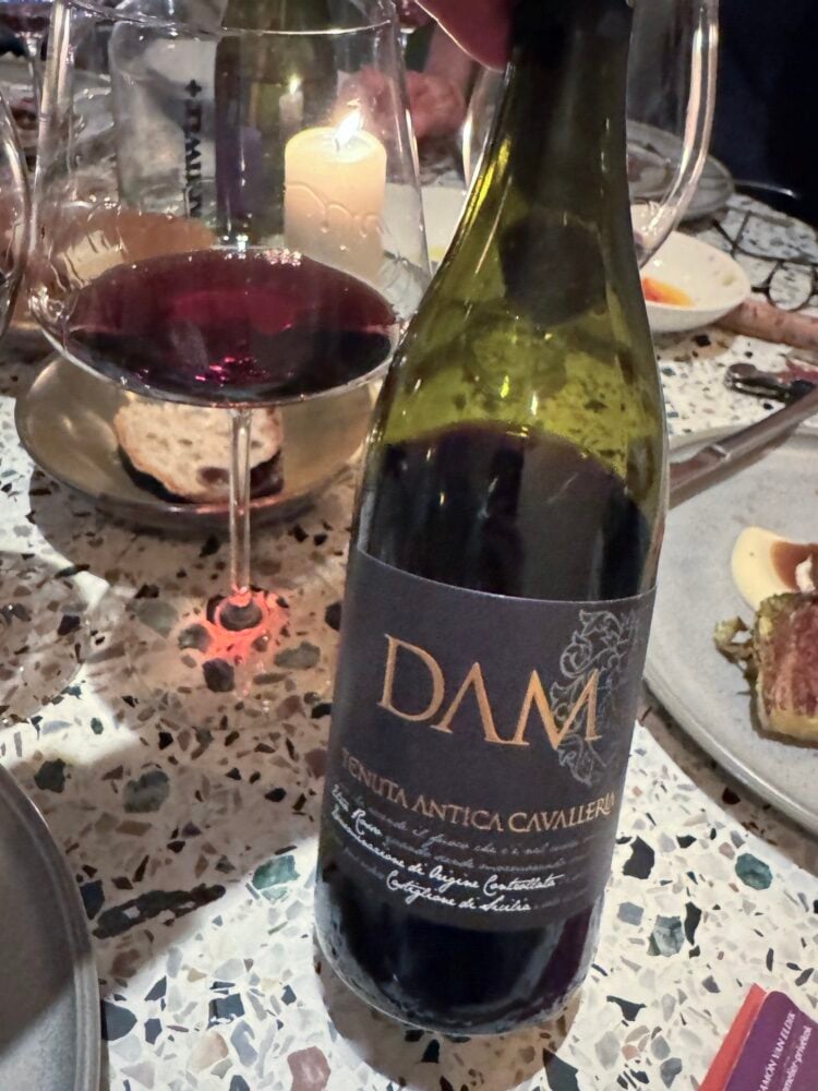 Fles Dam rode wijn van Tenuta Antica Cavalleria met een glas rode wijn en kaars