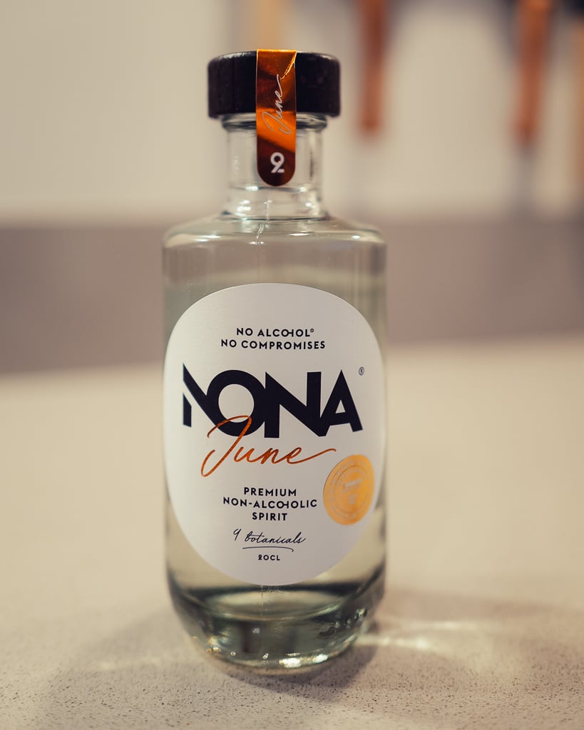 Fles NONA June, heldere alcoholvrije spirit met negen botanicals, in close-up op tafel