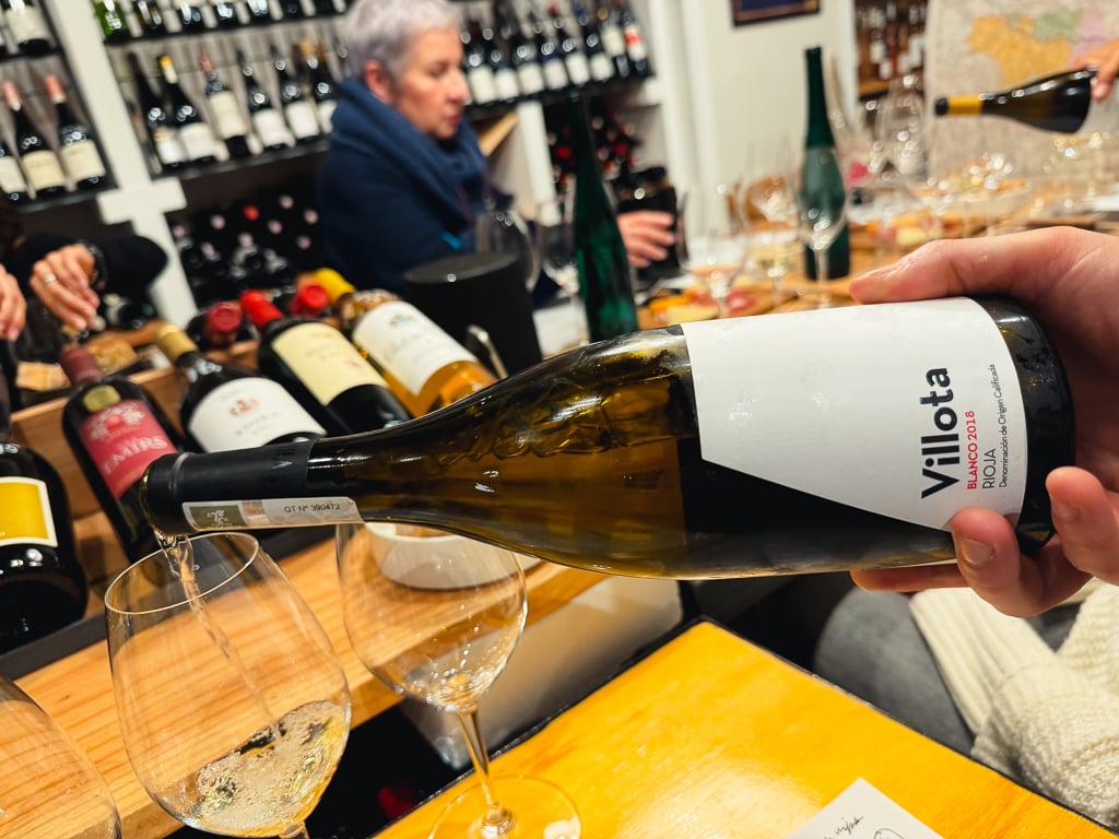Fles Villota Blanco wordt aan een proeftafel in glazen geschonken