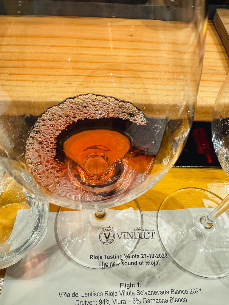 Glas zalmkleurige Villota rosé van bovenaf gezien op een proefkaart