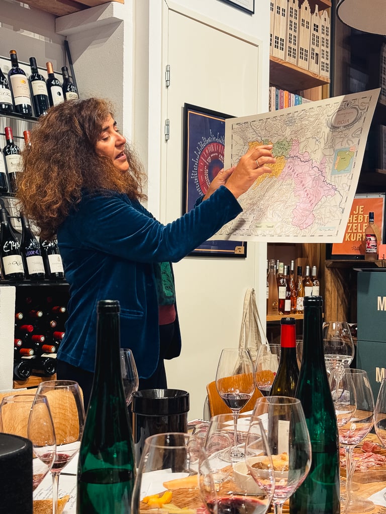 Carmen Pérez toont een wijnkaart van Rioja tijdens de masterclass aan tafel
