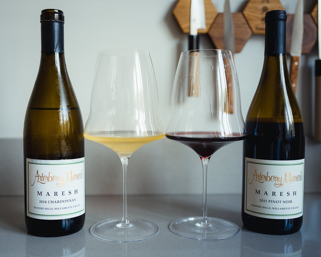 Chardonnay en Pinot Noir van Arterberry Maresh tussen twee glazen witte en rode wijn