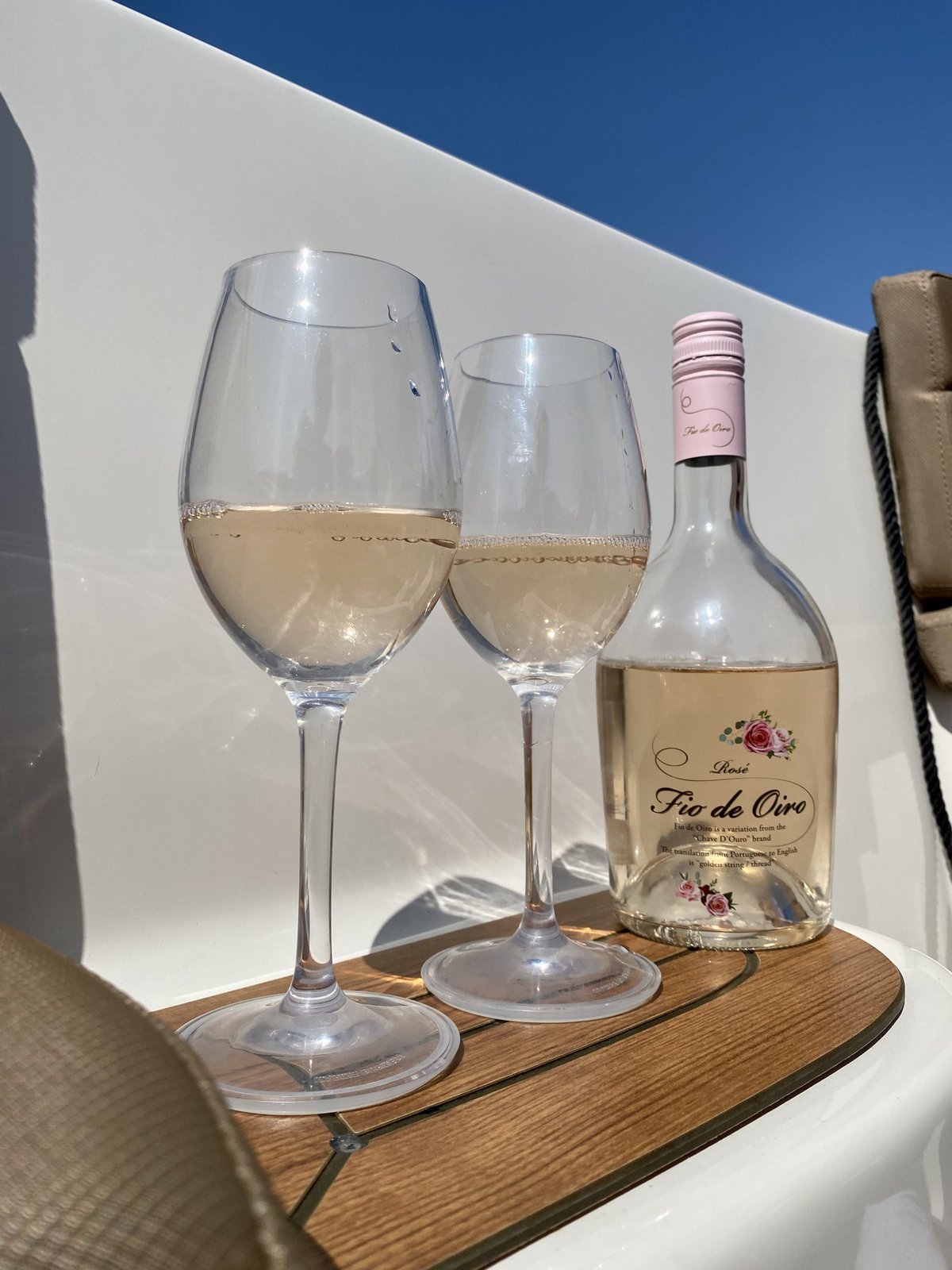 Fles Fio de Oiro rosé met twee glazen rosé op een tafeltje in de zon