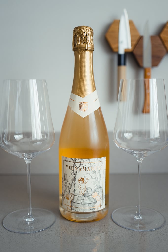 Fles Vignamante mousserende rosé met gouden hals tussen twee lege wijnglazen