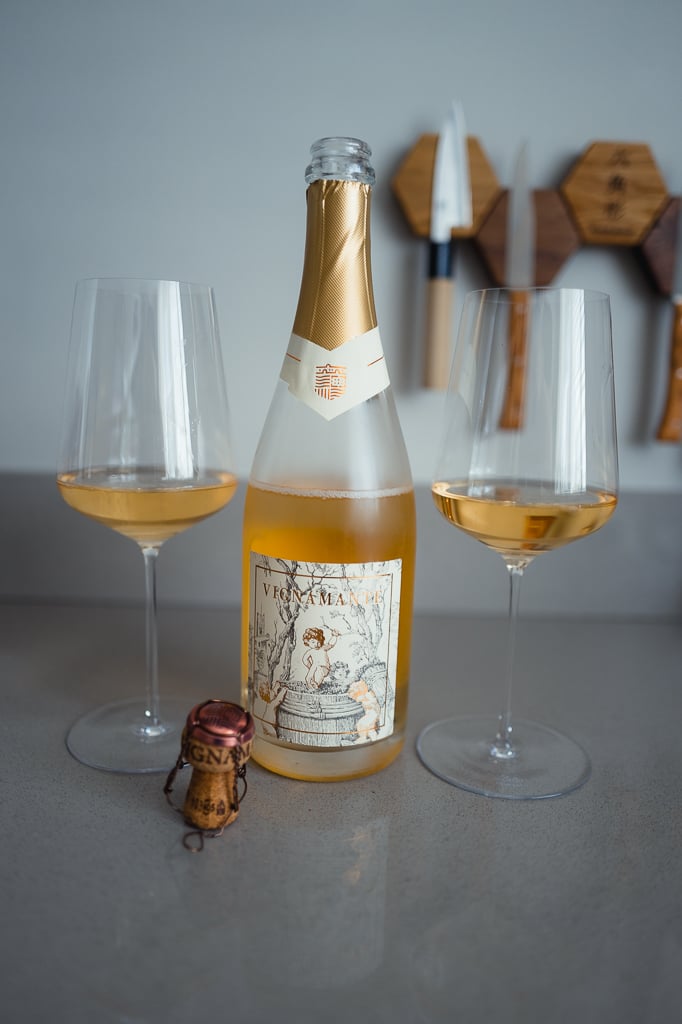 Geopende fles Vignamante rosé met kurk en twee glazen oud-roze mousserende wijn