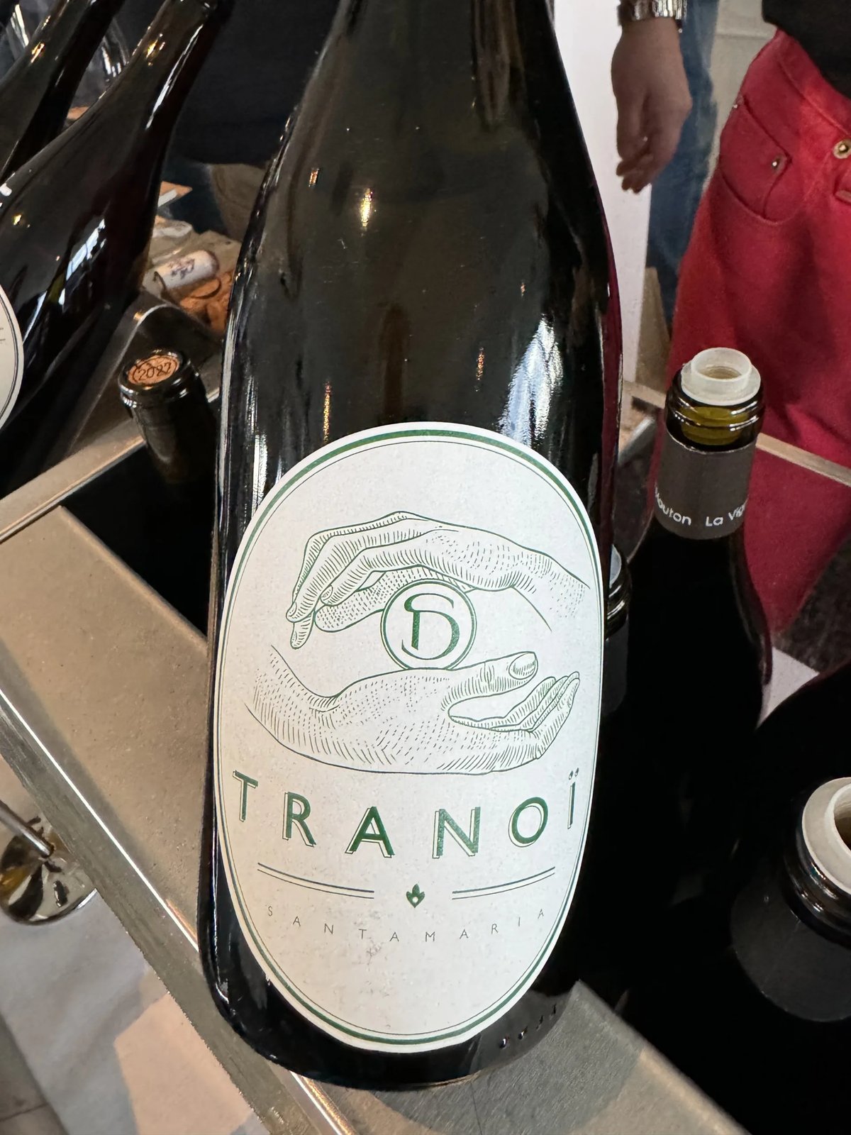 Fles Domaine Santamaria Tranoï met handenillustratie in groen op het etiket