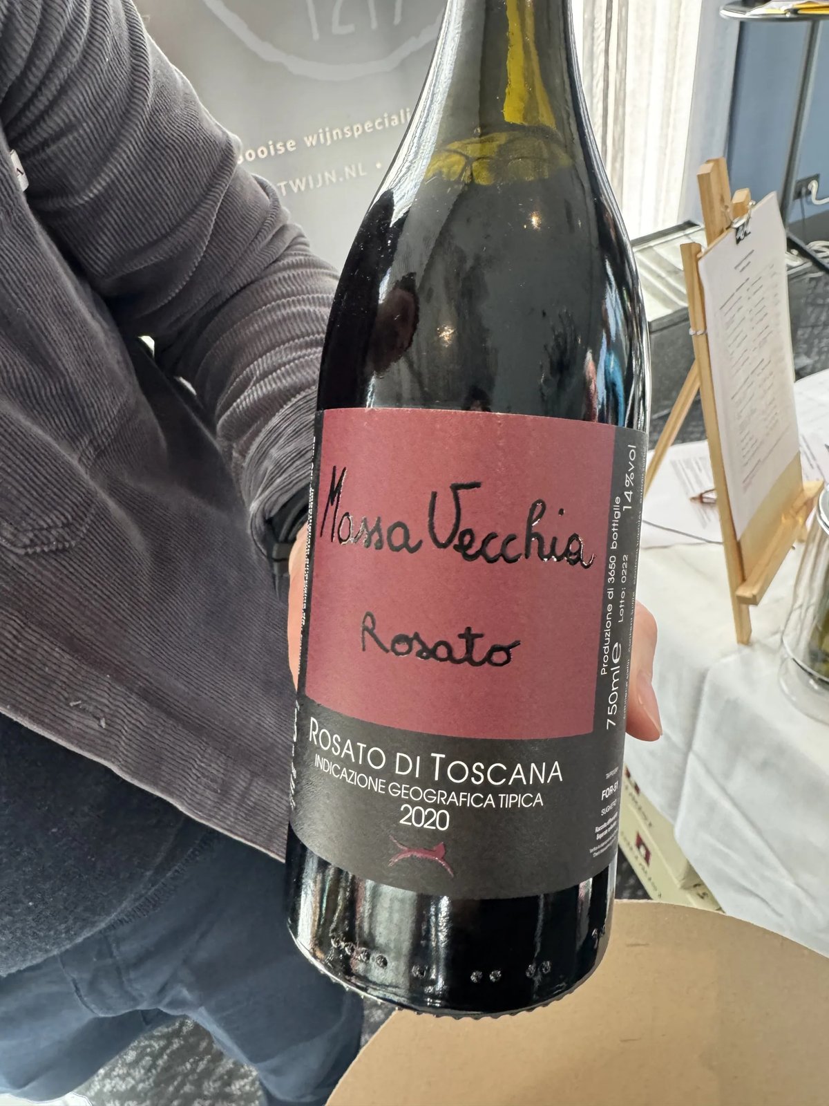 Hand houdt fles Massa Vecchia Rosato 2020 vast met handgeschreven rood etiket