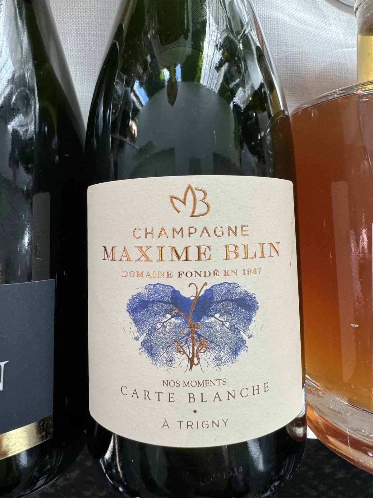 Fles Champagne Maxime Blin Carte Blanche met blauw vlindermotief op het etiket