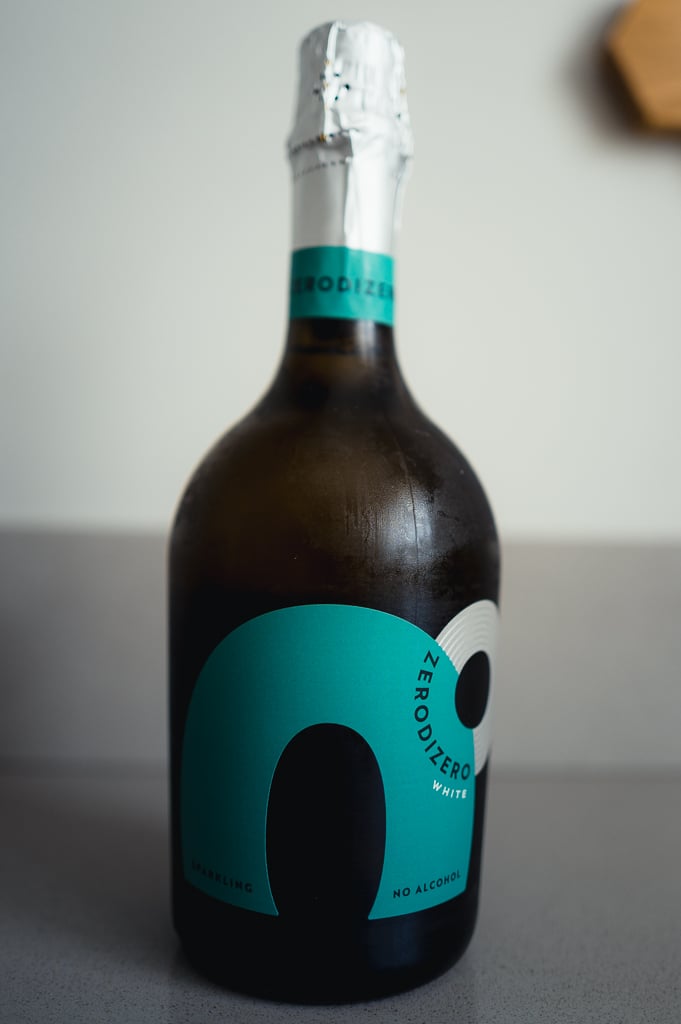 Donkere fles Zero di Zero White met tealblauw etiket en zilveren folie op een aanrecht