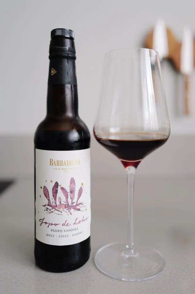 Fles Barbadillo Jopo de Lobo Pedro Ximénez naast een glas donkerrode PX