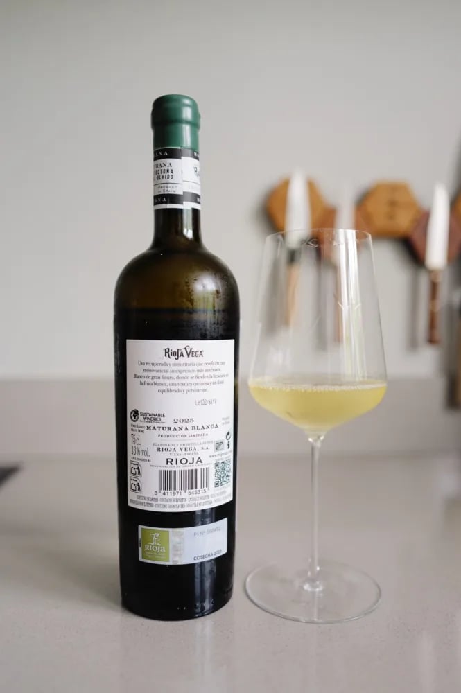 Achterlabel van de Rioja Vega Maturana Blanca 2025 met oogstjaar 2025 en het Sustainable Wineries-logo, naast een glas witte wijn
