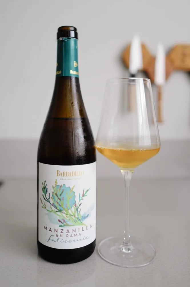 Fles Barbadillo Salicornia Manzanilla en Rama naast een glas goudgele manzanilla