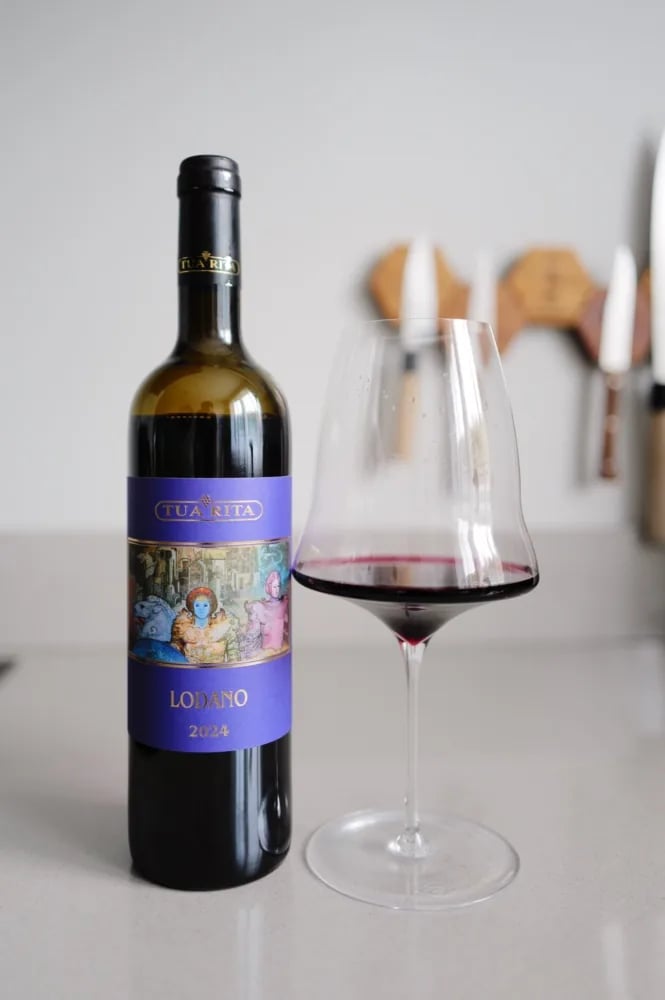Bottle of Tua Rita Lodano 2024 next to a glass of red wine