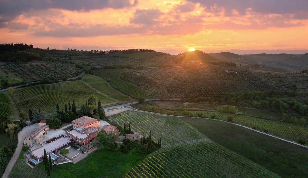 Luchtfoto van La Fattoria di Vignamaggio tussen wijngaarden en bos bij zonsondergang
