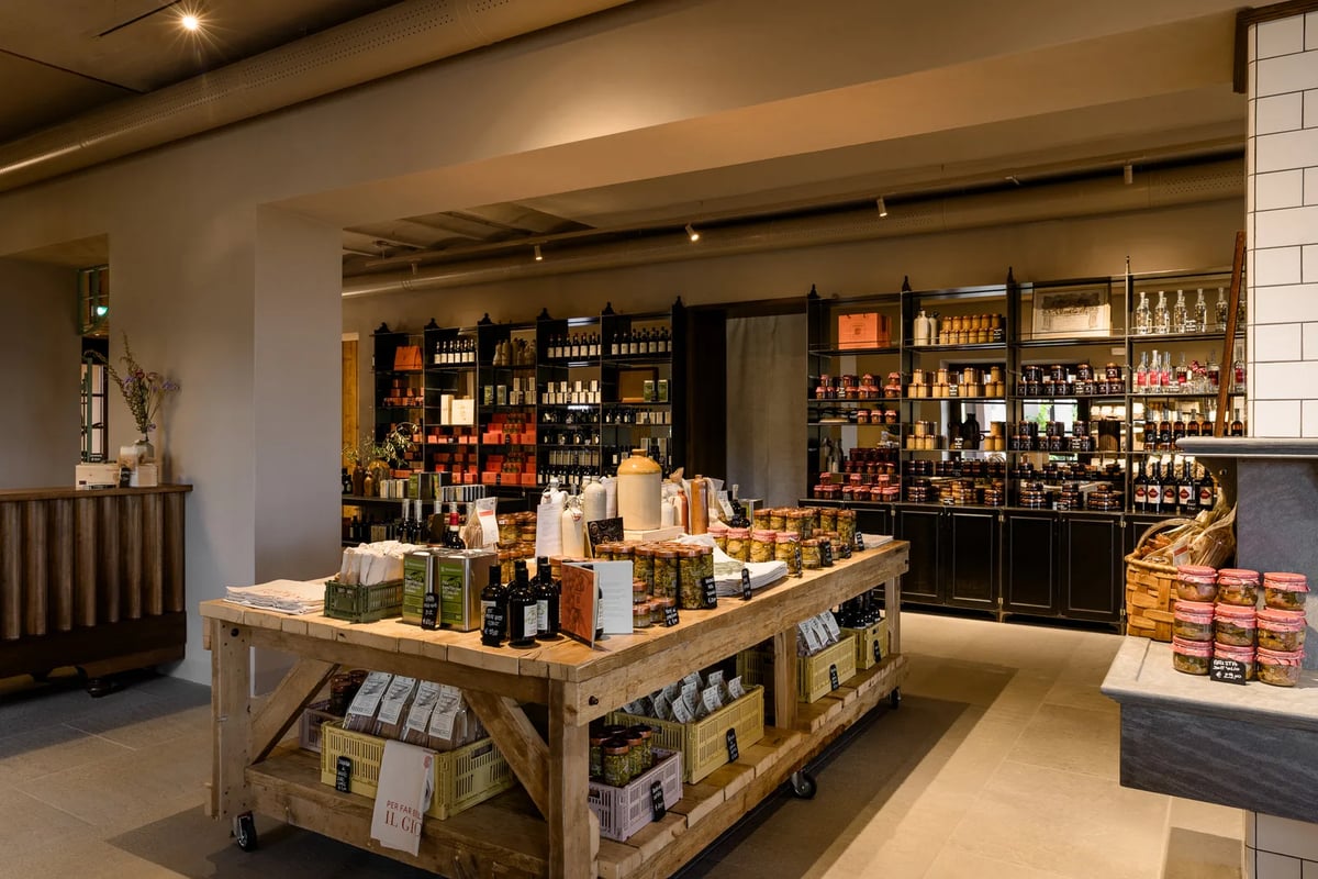 Winkel van La Fattoria di Vignamaggio met een tafel vol eigen producten en wanden met wijnflessen